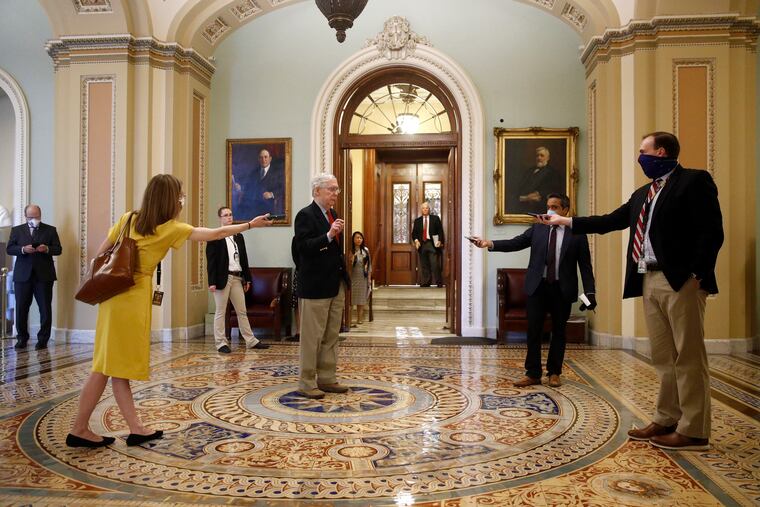 Senate Majority Leader Mitch McConnell of Ky., center, speaks with reporters outside the Senate chamber on Capitol Hill in Washington, Thursday, April 9, 2020. Senate Democrats on Thursday stalled President Donald Trump's request for $250 billion to supplement a "paycheck protection" program for businesses crippled by the coronavirus outbreak, demanding protections for minority-owned businesses and money for health care providers and state and local governments.