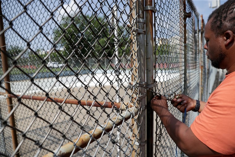 Donnell Martin, of the Belfield Recreation Center, locks the gate to the pool at the center in Philadelphia, PA on July 10, 2019. The pool was closed after a recent shooting nearby.