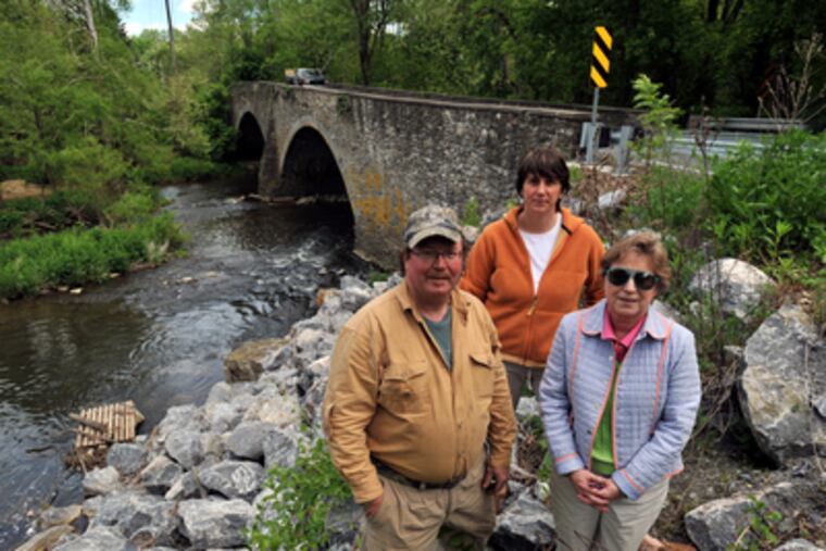 Rick Rasmussen (left to right), owner of Brandywine Outfitters and of the dam that crosses the Brandywine at Mortonville, Dee Durham, Executive Director of S.A.V.E, and Paula Coyne, Chairman of the East Fallowfield Historical Commission (and a board member of S.A.V.E.) stand in front of the Mortonville bridge over the Brandywine Creek.