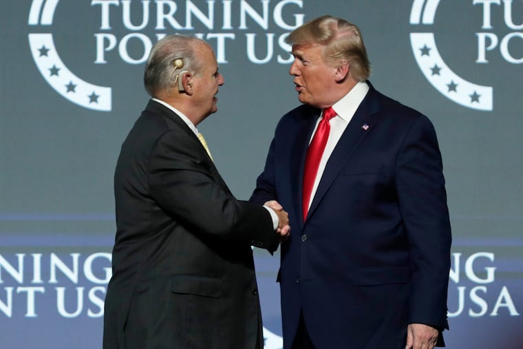 Rush Limbaugh, left, shakes hands with President Donald Trump as he introduces Trump at the Turning Point USA Student Action Summit at on Dec. 21, 2019, in West Palm Beach, Fla. Limbaugh died of lung cancer on Wednesday, Feb. 17, 2021, four weeks after Trump left office. He was memorialized as the "greatest of all time" on Fox's website, but to critics who saw Limbaugh as a spreader of bigotry, it was good riddance. Limbaugh remained at the top of the heap among radio hosts even until his death.