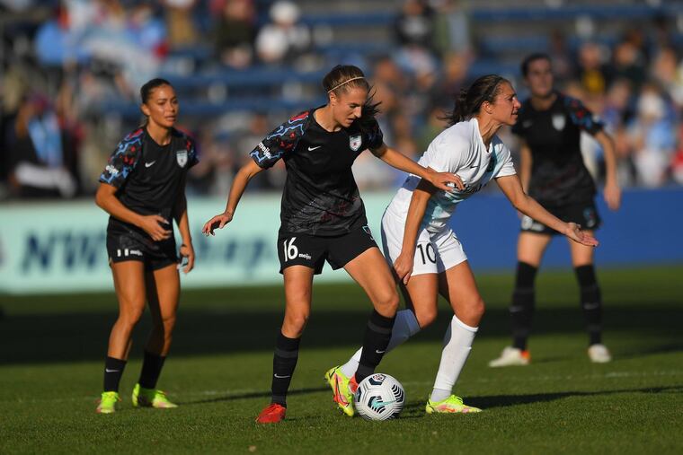 Carli Lloyd (right) battles against Sarah Woldmoe (center) as Sarah Gorden (left) looks on during Sunday's game.