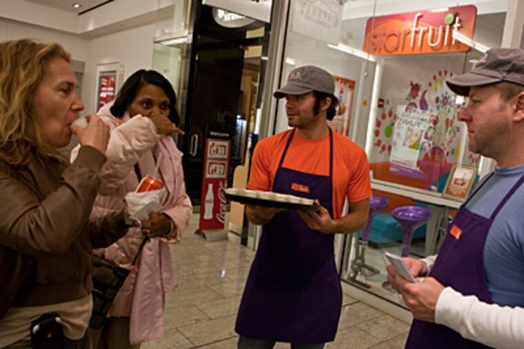 Jeff Paulus, right, manager of Starfruit Cafe, and Huber Trenado serve samples of kefir with fruits, a yogurt drink that is a staple in Eastern Europe, to Malkah Hegel, left, and Joan Obanner at Block 37 Pedway Level in Chicago, Illinois. (Zbigniew Bzdak/ Chicago Tribune/MCT)