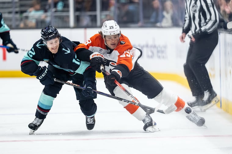 The Flyers' Nikita Grebenkin battles for the puck with Kraken forward Tye Kartye during the second period of Sunday's game in Seattle.