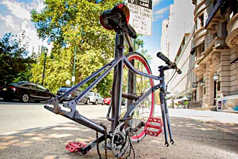 In the 1800 block of Walnut Street, across from Rittenhouse Square, a bicycle is secured to a bike rack with it's rear wheel missing.Melissa Dribben writes about the state of bike thefts in Philadelphia and the Bicycle Coalition's effort to stem tide working with police and Azavea to create a real time map of where thefts take place. ( Ed Hille / Staff Photographer )