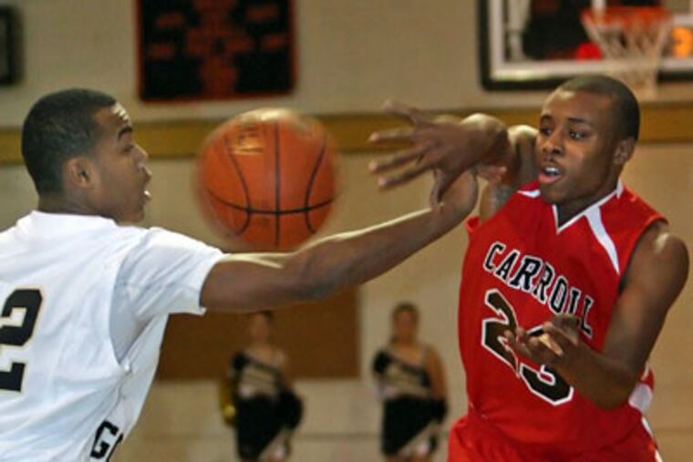 Archbishop Carroll's Juan-ya Green passes around Neumann-Goretti's Tony Chennault during the first quarter Friday in South Philadelphia. (Steven M. Falk / Staff Photographer)