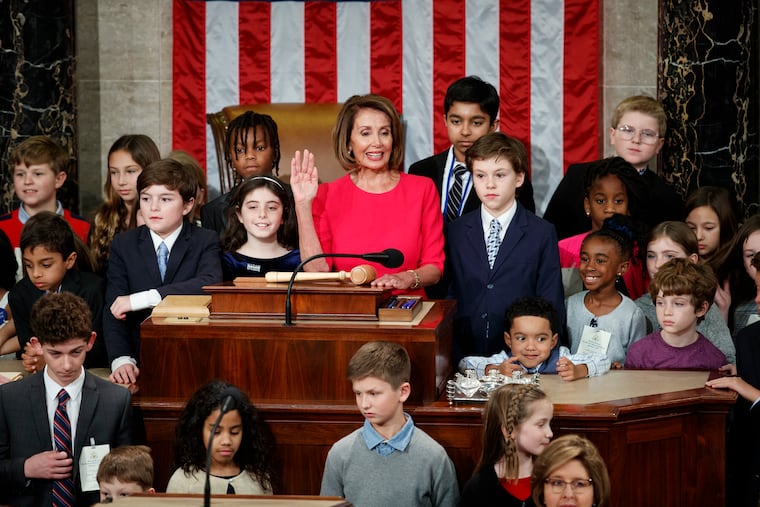 Nancy Pelosi of California, surrounded by her grandchildren and other children raises her right hand as Rep. Don Young, R-Alaska, the longest-serving member of the House, administers the oath to Pelosi to become the Speaker of the House Thursday.