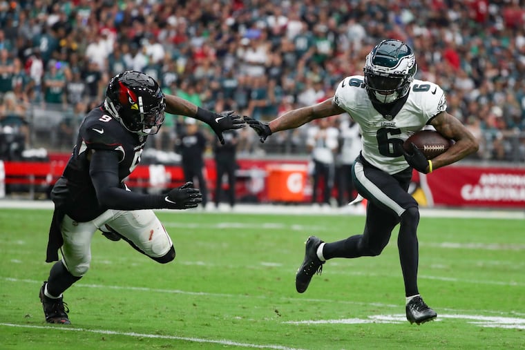 Eagles wide receiver DeVonta Smith carries the ball past Arizona Cardinals linebacker Isaiah Simmons.