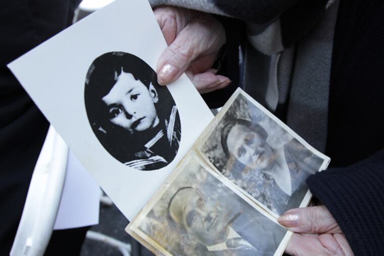Holocaust survivor Clara Vinokur, of Northeast Philadelphia, displays photos of her mother, father, and brother who were killed during the Holocaust. Vinokur attended the annual Memorial Ceremony for the Six Million Jewish Martyrs in Philadelphia on April 27, 2014. It marked the 50th anniversary of the dedication of the monument. (DAVID MAIALETTI/Staff Photographer)