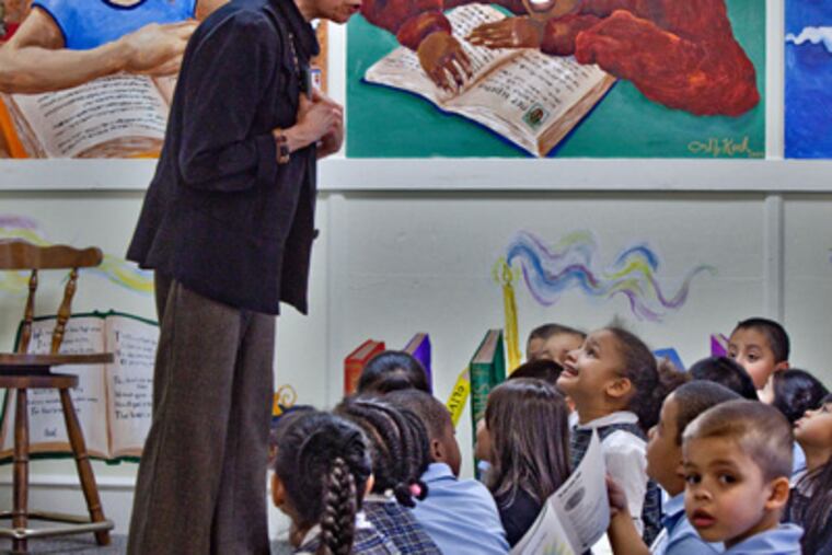 Judy Nadell reads at St. Joseph's Pro-Cathedral School in Camden, one of five Catholic schools that she and her husband, John Langan, are supporting. (David M Warren / Staff Photographer)