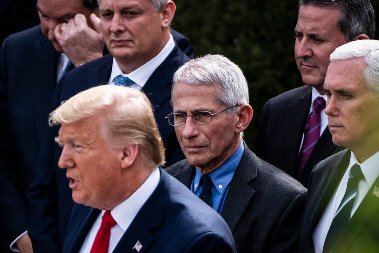 Dr. Anthony Fauci, center, standing between former President Donald Trump and Vice President Mike Pence, right, in March 2020.