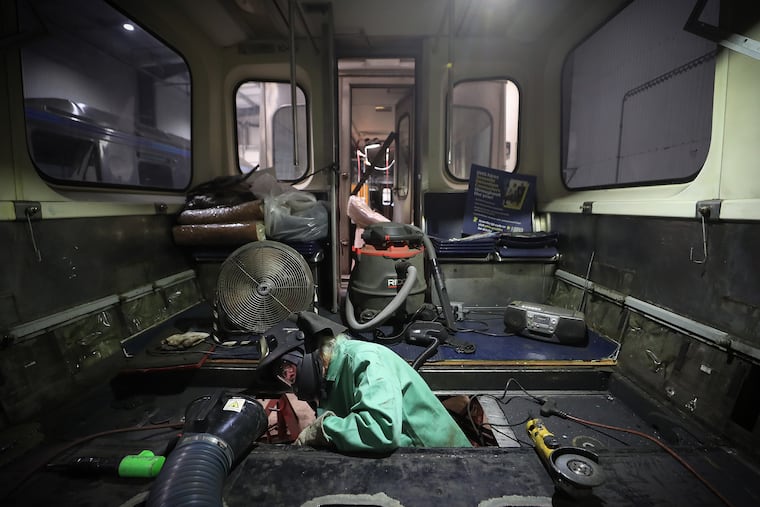 A SEPTA welder is shown in 2023 working on repairs to a Market-Frankford Line car.
