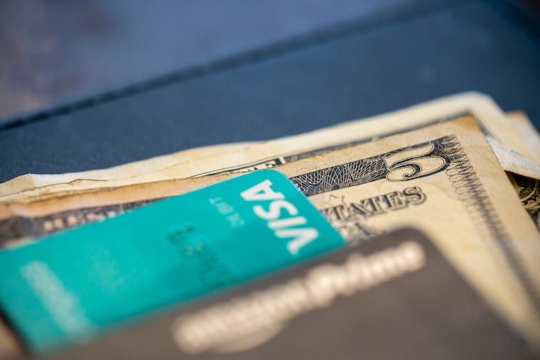 FILE - In this Aug. 11, 2019 file photo, U.S. currency and credit cards sit on a table at a restaurant in New Orleans. With inflation at 7.1% in November, it’s not surprising that savings aren’t going as far as they used to.
