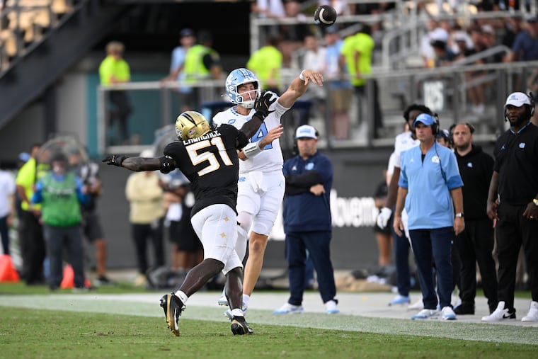 North Carolina quarterback Max Johnson, right, throws a pass as Central Florida edge Malachi Lawrence (51) pressures during the second half of an NCAA football game, Saturday, Sept. 20, 2025, in Orlando, Fla. (AP Photo/Phelan M. Ebenhack)