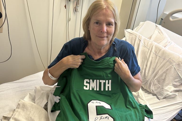66-year-old Pat Schmus with her signed DeVonta Smith jersey.