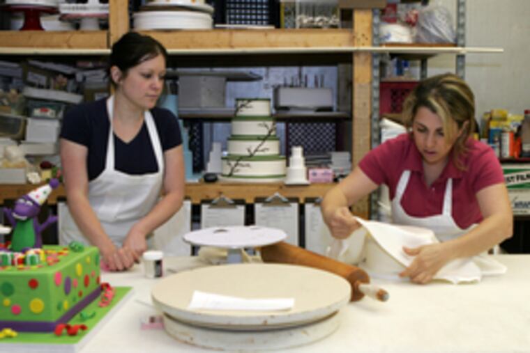 Cake designer Heather Smith (left) and Nina Asadoorian work on a confection for a client at Rilling's Bakery.