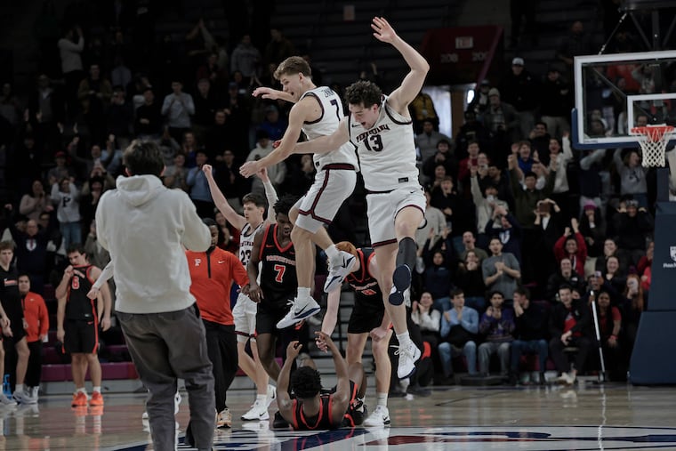 Penn’s Michael Zanoni (left) and Dalton Scantlebury celebrate after the Quakers knocked off Princeton on Saturday at the Palestra. The win snapped an eight-year losing streak to the Tigers.