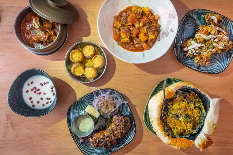A selection of signature dishes from Unapologetic Foods. Upper left: Junglee maas goat curry, dahi batata puri, paneer khurchan, and kale pakoda. Bottom: Raita, bhatti da murgh, and lucknow dum biryani.