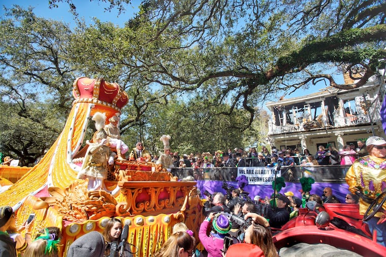 Rex royalty take an extended pause in front of the charred carcass of a St. Charles Avenue mansion to make a toast, carrying on a tradition that began in 1907, at a house that looms large in krewe and Mardi Gras history in New Orleans, Tuesday, March 5, 2019. (Chris Granger/The Advocate via AP)
