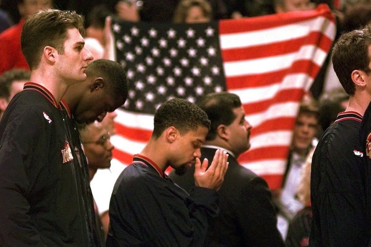 In this March 1996 file photo, Denver Nuggets guard Mahmoud Abdul-Rauf stands with his teammates and prays during the national anthem before an NBA game. This was his first game back since he was suspended by the NBA on March 12, 1996, for refusing to participate in the national anthem during a pre-game ceremony.