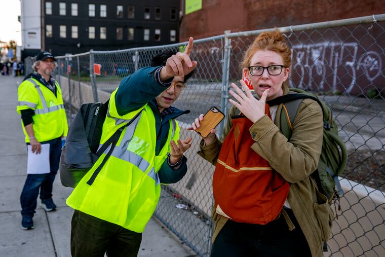City transit project coordinator Benjamin She assists a rider who had received conflicting information on where to board and was running late.