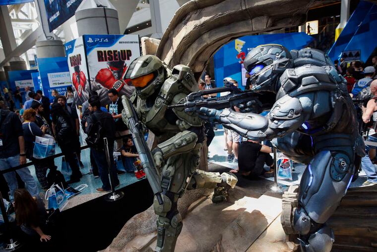 Microsoft Xbox's Halo 5: Guardians characters stand as attendees await the opening of the E3 Electronic Entertainment Expo on Tuesday in Los Angeles. E3, a trade show for computer and video games, draws professionals to experience the future of interactive entertainment, as well as to see new technologies and never-before-seen products.