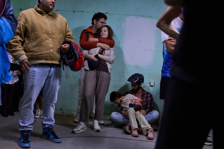 People take shelter as air raid sirens warning of incoming Iranian missiles in Tel Aviv, Israel, Saturday, March 7, 2026.