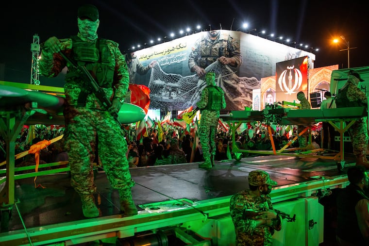 Members of Iran’s Islamic Revolutionary Guard Corps stand near a drone display at a government-organized march in Tehran, April 29, 2026.