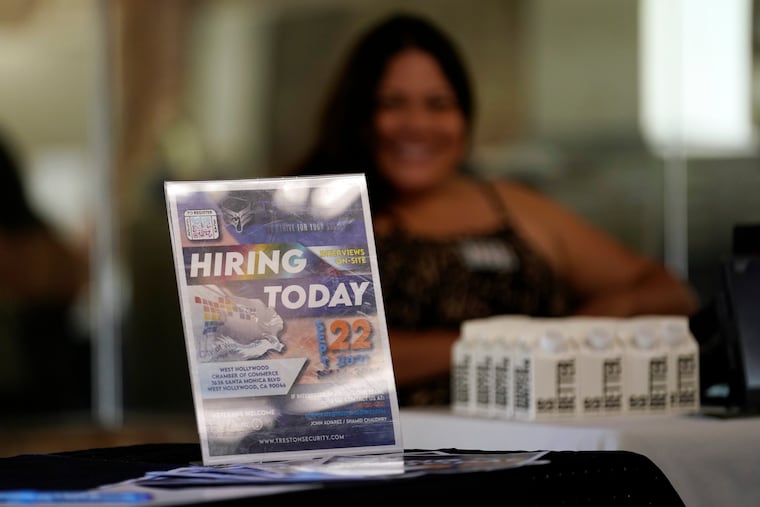 A hiring sign is placed at a booth for prospective employers during a job fair Wednesday, Sept. 22, 2021, in the West Hollywood section of Los Angeles.