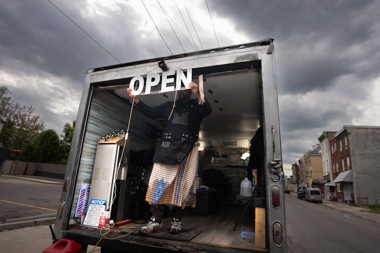 Siddiq stands in the entrance to Nice Cutz, his mobile barbershop that he operates out of a box truck.