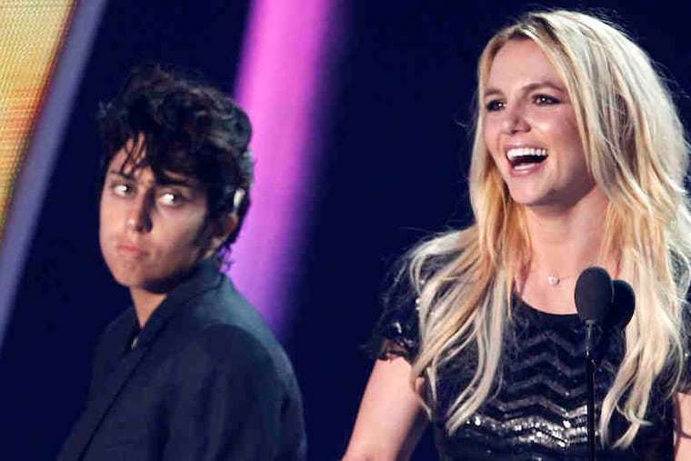 Britney Spears accepts her Video Vanguard award as Lady Gaga, in her Jo Calderone guise, looks on.