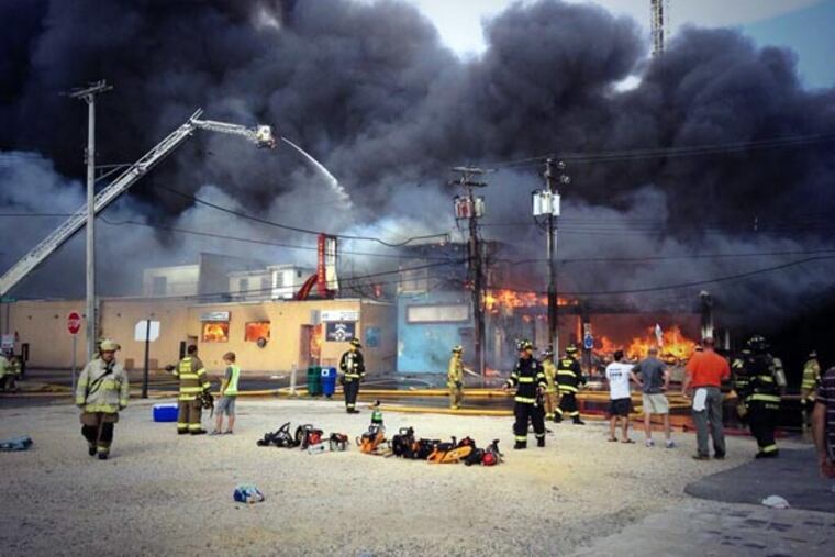 Firefighters battle a raging fire on the boardwalk in Seaside Heights, N.J. that apparently started in an ice cream shop and has spread several blocks down, Thursday, Sept. 12, 2013. The boardwalk was damaged in Superstorm Sandy and was being repaired. (AP Photo/The Asbury Park Press, Kristi Funderburk)