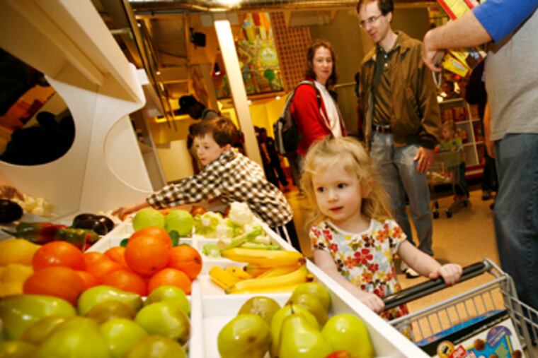 At a preview opening, 3-year-old Willa Salmanson from Narberth "shops" in the supermarket at the Please Touch Museum in Memorial Hall. (Eric Mencher/Staff Photographer)