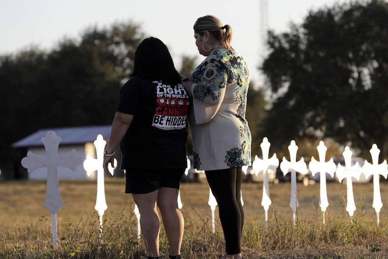 Laura Torres, right, and Sonia Yanez visit a line of crosses before a vigil for the victims of Sunday’s First Baptist Church shooting, Monday, Nov. 6, 2017, in Sutherland Springs, Texas.