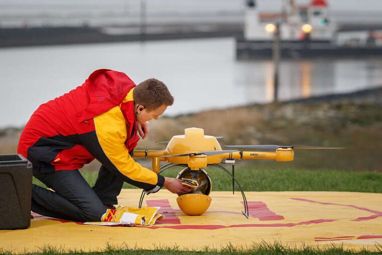 An employee places a parcel into the cargo storage pod of a DHL delivery drone during testing by Deutsche Post's parcel delivery unit in Norddeich, Germany. Deutsche Post and DHL handled more than one billion items in Germany last year, a market share exceeding 42 percent of parcel deliveries by value. The trial run may help Deutsche Post stake a claim to a part of the logistics chain in which postal operators and express service providers are increasingly being challenged by Internet retailers.