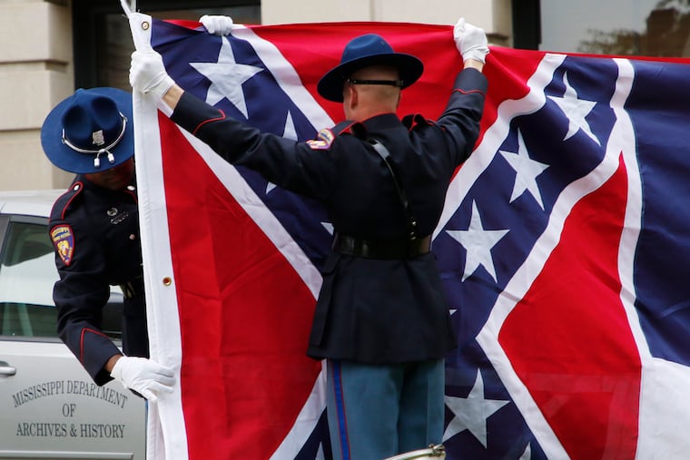 A Mississippi Highway Safety Patrol honor guard folds the retired Mississippi state flag after it was raised over the Capitol grounds one final time in Jackson, Miss., on July 1, 2020. Vestiges of the Civil War and Jim Crow segregation are coming down across the Old Confederacy as part of a national reckoning on race and white supremacy. A diversifying Democratic Party hopes the changes in symbols are part of a more fundamental shift in a region that dominated by Republicans for a generation – and white conservative Democrats a century before that.
