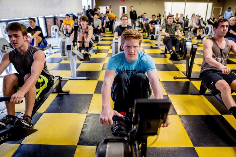 Members of the Moorestown High squad, (from left) Brent Jones, Danny Schultz and Taylor LaRosa, working out on indoor rowing machines as they wait for a chance to get on the river.