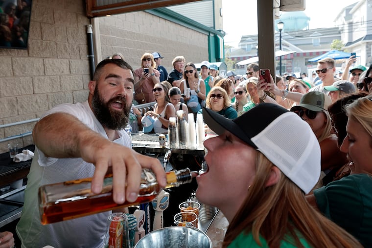 Eagles center Jason Kelce pours a fireball for Abby Davidson of Kennett Square while working the Patty’s Green bar at O'Donnell's Pour House in Sea Isle City, N.J., on Wednesday.