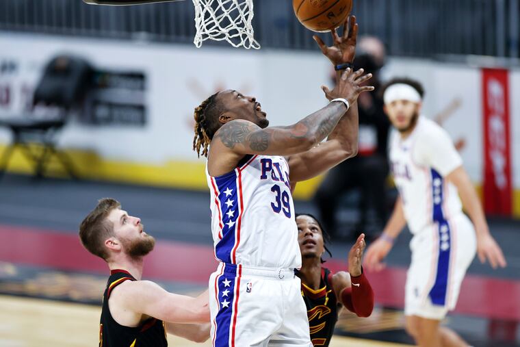 The Sixers' Dwight Howard puts up a shot against the Cleveland Cavaliers' Isaac Okoro, right, and Dean Wade in the second half.