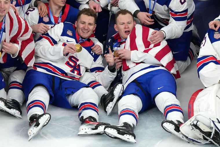 Matthew Tkachuk (left) and Brady Tkachuk pose for the team picture after receiving their gold medals.