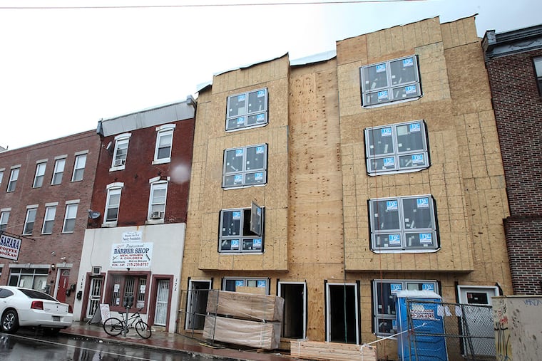 Ron Redmond, the barber at 1729 Cecil B. Moore, is sandwiched between construction going up for past two months. Wednesday, October 15, 2014. ( Steven M. Falk / Staff Photographer )