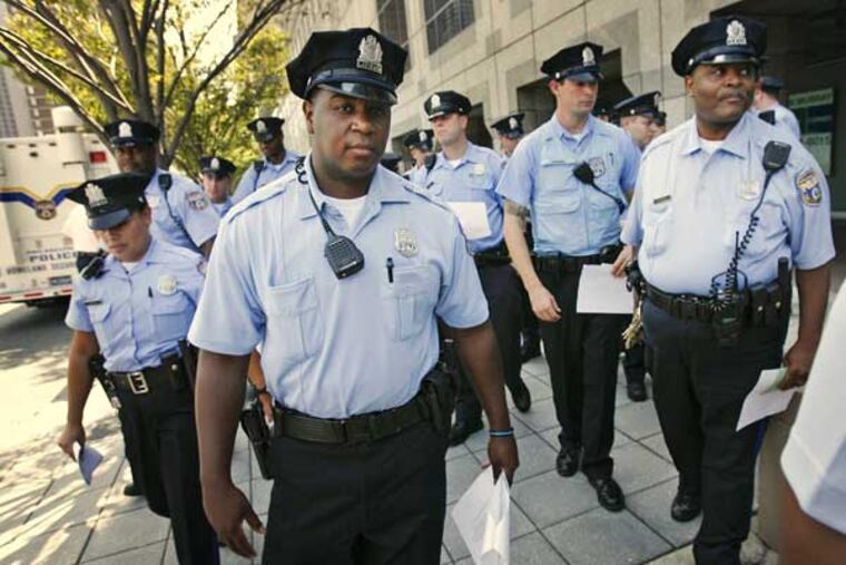 Philadelphia police officers break formation at 22nd St and John F. Kennedy Blvd.to walk to their patrol vehicles for the start of the rapid response drill in Center City.