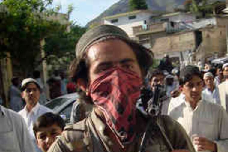 A Pakistani Taliban member leaves Buner. Militants who had seized the northwestern district began pulling out Friday.