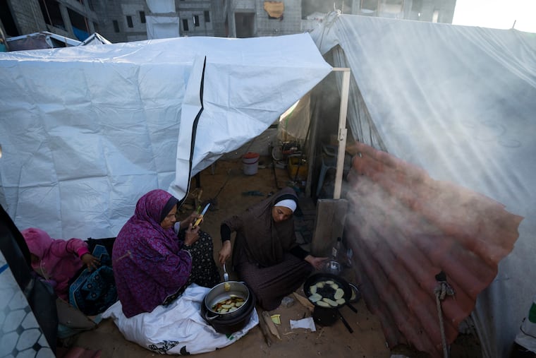 Randa Baker, right, who was displaced by the Israeli bombardment of the Gaza Strip, prepares the Iftar meal with her mother on the first day of the Muslim holy fasting month of Ramadan at a makeshift tent camp in the Muwasi area of southern Gaza on Monday, March 11, 2024.