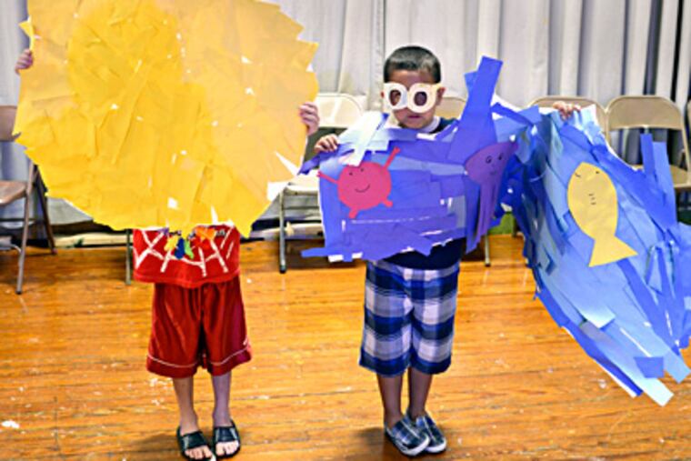Lance Worley (left) and Arturo Sequeira portray the sun and the sea during a rehearsal for a performance of "Surfin' USA" in the summer program in Bucks County. TOM GRALISH / Staff Photographer