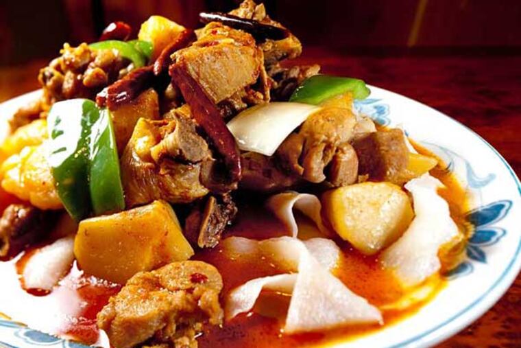 The sauteed spicy chicken and noodles is one of the top dishes at Xi'an Sizzling Woks, listed on the menu under the chef's recommendations.