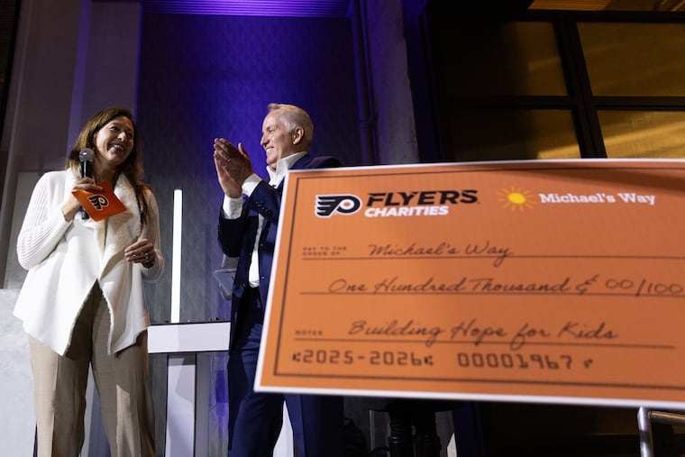 Blair Listino and Chris McElwee present a donation during the Michael’s Way Fashion Show at The Switch House by Cescaphe in Philadelphia on Nov. 18.