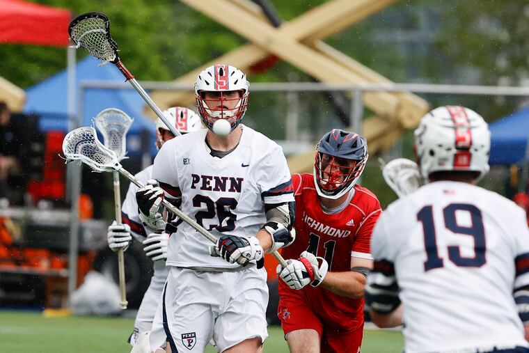 Penn's Sam Handley (left) passes the lacrosse ball to teammate Ben Bedard (right) past Richmond's Shayne Grant in the second quarter during the first round NCAA Men's Lacrosse Championship in Penn Park on Saturday, May 14, 2022.