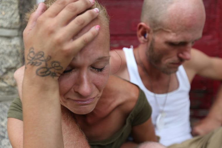 Carol Yancer (left) cries while she and Ray Rivero, her boyfriend, talk about getting clean and off the streets as they sit on a stoop along Somerset Street in Philadelphia.