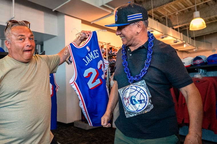 Roger Franco (left) and Humberto Alarcon were among the Sixers fans shopping for LeBron James merchandise during a two-day sale at the 76ers team store at Xfinity Mobile Arena.