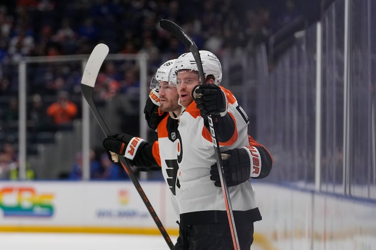 The Flyers' Joel Farabee, left, celebrates with Cam York, right, after York scored a goal against the Islanders during the third period on Thursday.